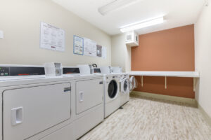 Interior laundry room, 2 washers 2 dryers, shelf for folding clothes.
